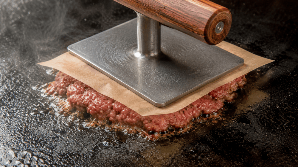 Smash Burger mit kräftiger Kruste auf gusseiserner Grillplatte